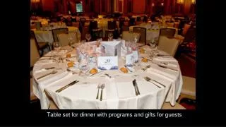 Table set for dinner with programs and gifts for guests
